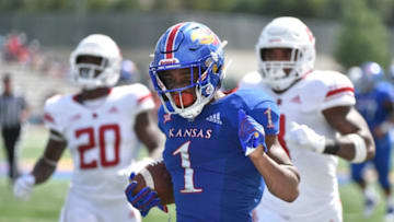 LAWRENCE, KS - SEPTEMBER 15: Running back Pooka Williams Jr. #1 of the Kansas Jayhawks runs for 52-yard touchdown defensive back Avery Young #20 and Tyshon Fogg #8 of the Rutgers Scarlet Knights in the fourth quarter at Memorial Stadium on September 15, 2018 in Lawrence, Kansas. (Photo by Ed Zurga/Getty Images)