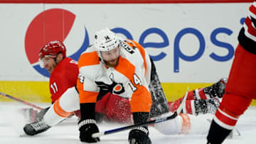 RALEIGH, NC - JANUARY 7: Jordan Staal #11 of the Carolina Hurricanes and Sean Couturier #14 of the Philadelphia Flyers collide during an NHL game on January 7, 2020 at PNC Arena in Raleigh, North Carolina. (Photo by Gregg Forwerck/NHLI via Getty Images)