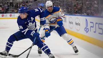 Mar 13, 2023; Toronto, Ontario, CAN; Toronto Maple Leafs forward Mitchell Marner (16) carries the puck past Buffalo Sabres forward Dylan Cozens (24) during the first period at Scotiabank Arena. Mandatory Credit: John E. Sokolowski-USA TODAY Sports