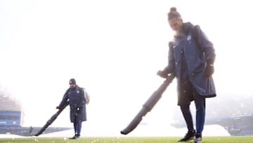Ground staff members prepare the pitch after the covers are removed prior to the FA Women's Super League match between Chelsea and Liverpool at Kingsmeadow (Photo by Clive Rose/Getty Images)