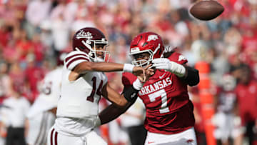 Oct 21, 2023; Fayetteville, Arkansas, USA; Mississippi State Bulldogs quarterback Mike Wright (14) throws a pass against Arkansas Razorbacks defensive lineman Trajan Jeffcoat (7) during the first quarter at Donald W. Reynolds Razorback Stadium. Mandatory Credit: Nelson Chenault-USA TODAY Sports