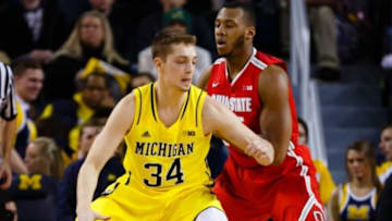 Feb 22, 2015; Ann Arbor, MI, USA; Michigan Wolverines forward Mark Donnal (34) is defended by Ohio State Buckeyes center Trey McDonald (55) at Crisler Center. Mandatory Credit: Rick Osentoski-USA TODAY Sports