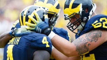 Aug 30, 2014; Ann Arbor, MI, USA; Michigan Wolverines running back De'Veon Smith (4) receives congratulations from offensive linesman Mason Cole (52) after scoring a touchdown against the Appalachian State Mountaineers at Michigan Stadium. Mandatory Credit: Rick Osentoski-USA TODAY Sports