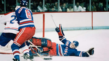 MONTREAL, CANADA - CIRCA 1990: John Vanbiesbrouck #34 of the New York Rangers slides to make a save on a shot by Chris Chelios #24 of the Montreal Canadiens Circa 1990 at the Montreal Forum in Montreal, Quebec, Canada. (Photo by Denis Brodeur/NHLI via Getty Images)