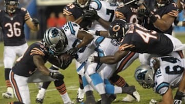 Aug 9, 2013; Charlotte, NC, USA; Carolina Panthers running back Tauren Poole (33) runs through the line as he is pursued by Chicago Bears linebacker Lawrence Wilson (49) and cornerback Demontre Hurst (30) while playing at Bank of America Stadium. Carolina wins 24-17. Mandatory Credit: Sam Sharpe-USA TODAY Sports