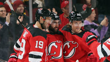 NEWARK, NEW JERSEY - DECEMBER 03: Kyle Palmieri #21 of the New Jersey Devils (C) celebrates his goal at 16:31 of the first period against the Vegas Golden Knights and is joined by Travis Zajac #19 (L) and Blake Coleman #20 (R) at the Prudential Center on December 03, 2019 in Newark, New Jersey. (Photo by Bruce Bennett/Getty Images)