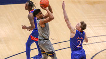 Feb 6, 2021; Morgantown, West Virginia, USA; West Virginia Mountaineers guard Taz Sherman (12) shoots a jumper over Kansas Jayhawks guard Christian Braun (2) during the second half at WVU Coliseum. Mandatory Credit: Ben Queen-USA TODAY Sports