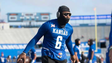 Kansas junior quarterback Jalon Daniels (6) grabs a ball during pregame before Saturday's game against Oklahoma inside David Booth Kansas Memorial Stadium.