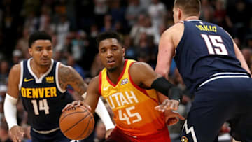 DENVER, COLORADO - FEBRUARY 28: Donovan Mitchell #45 of the Utah Jazz drives against Gary Harris #14 and Nikola Jokic #15 of the Denver Nuggets in the fourth quarter at the Pepsi Center on February 28, 2019 in Denver, Colorado. (Photo by Matthew Stockman/Getty Images)
