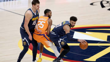 DENVER, COLORADO - JANUARY 01: Jamal Murray #27 of the Denver Nuggets drives against Mikal Bridges #25 of the Phoenix Suns on a pick set by Nikola Jokic #15 in the fourth quarter at Ball Arena on January 01, 2021 in Denver, Colorado. NOTE TO USER: User expressly acknowledges and agrees that, by downloading and or using this photograph, User is consenting to the terms and conditions of the Getty Images License Agreement. (Photo by Matthew Stockman/ Getty Images)
