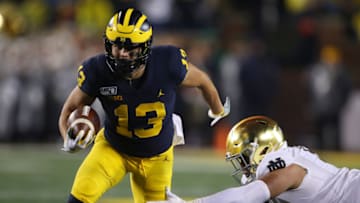 ANN ARBOR, MICHIGAN - OCTOBER 26: Tru Wilson #13 of the Michigan Wolverines avoids the tackle of Myron Tagovailoa-Amosa #95 of the Notre Dame Fighting Irish on his way to a second half touchdown at Michigan Stadium on October 26, 2019 in Ann Arbor, Michigan. Michigan won the game 45-14. (Photo by Gregory Shamus/Getty Images)