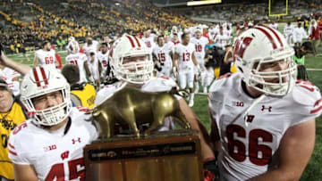 IOWA CITY, IOWA- SEPTEMBER 22: Fullback Alec Ingold #45, offensive lineman Michael Dieter #63 and offensive lineman Tyler Beach #65 of the Wisconsin Badgers carry the Heartland Trophy off the field after defeating the Iowa Hawkeyes, on September 22, 2018 at Kinnick Stadium, in Iowa City, Iowa. (Photo by Matthew Holst/Getty Images)