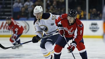 Jan 16, 2016; Buffalo, NY, USA; Washington Capitals defenseman Dmitry Orlov (9) prepares to shoot the puck as Buffalo Sabres defenseman Rasmus Ristolainen (55) defends during the first period at First Niagara Center. Mandatory Credit: Kevin Hoffman-USA TODAY Sports