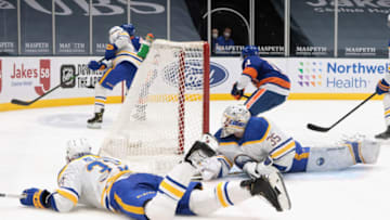 UNIONDALE, NEW YORK - FEBRUARY 22: Colin Miller #33 and Linus Ullmark #35 of the Buffalo Sabres block the net during the second period against the New York Islanders at the Nassau Coliseum on February 22, 2021 in Uniondale, New York. (Photo by Bruce Bennett/Getty Images)