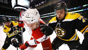 BOSTON, MA - FEBRUARY 27: Lucas Wallmark #71 of the Carolina Hurricanes fights for the puck with David Krejci #46 and Charlie McAvoy #73 of the Boston Bruins during a game at TD Garden on February 27, 2018 in Boston, Massachusetts. NOTE TO USER: User expressly acknowledges and agrees that, by downloading and or using this photograph, User is consenting to the terms and conditions of the Getty Images License Agreement. (Photo by Adam Glanzman/Getty Images)