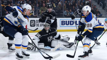 LOS ANGELES, CA - DECEMBER 23: Goaltender Jonathan Quick #32 of the Los Angeles Kings tends net and Ben Hutton #15 of the Los Angeles Kings looks on while Jacob de la Rose #61 and Mackenzie MacEachern #28 of the St. Louis Blues maneuver near the crease during the second period of the game at STAPLES Center on December 23, 2019 in Los Angeles, California. (Photo by Adam Pantozzi/NHLI via Getty Images)
