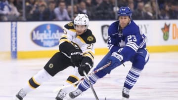 Mar 26, 2016; Toronto, Ontario, CAN; Boston Bruins right wing Loui Eriksson (21) moves the puck while Toronto Maple Leafs center Brooks Laich (23) defends at Air Canada Centre. The Bruins beat the Maple Leafs 3-1. Mandatory Credit: Tom Szczerbowski-USA TODAY Sports