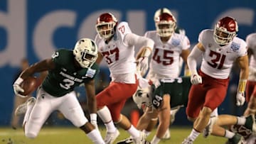 SAN DIEGO, CA - DECEMBER 28: LJ Scott #3 of the Michigan State Spartans eludes Justus Rogers #37; Logan Tago #45 and Isaac Dotson #31 of the Washington State Cougars during the first half of the SDCCU Holiday Bowl at SDCCU Stadium on December 28, 2017 in San Diego, California. (Photo by Sean M. Haffey/Getty Images)