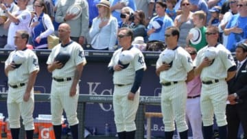 May 18, 2014; Kansas City, MO, USA; Kansas City Royals manager Ned Yost (center) stands with his coaches, wearing 1920's Kansas City Monarchs uniforms during the National Anthem before the game against the Baltimore Orioles during the first inning at Kauffman Stadium. Mandatory Credit: Peter G. Aiken-USA TODAY Sports