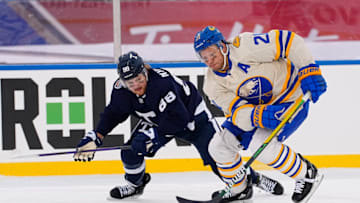 Mar 13, 2022; Hamilton, Ontario, CAN; Buffalo Sabres forward Kyle Okposo (21) gets past Toronto Maple Leafs forward William Nylander (88) during the third period in the 2022 Heritage Classic ice hockey game at Tim Hortons Field. Mandatory Credit: John E. Sokolowski-USA TODAY Sports