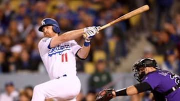 LOS ANGELES, CA - MAY 23: Logan Forsythe #11 of the Los Angeles Dodgers hits a ground rule double in front of Chris Iannetta #22 of the Colorado Rockies, to score Justin Turner #10 for a 1-0 lead during the fourth inning at Dodger Stadium on May 23, 2018 in Los Angeles, California. (Photo by Harry How/Getty Images)