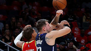 ATLANTA, GEORGIA - OCTOBER 21: Trae Young #11 of the Atlanta Hawks attempts a steal against Luka Doncic #77 of the Dallas Mavericks during the first half at State Farm Arena on October 21, 2021 in Atlanta, Georgia. NOTE TO USER: User expressly acknowledges and agrees that, by downloading and or using this photograph, User is consenting to the terms and conditions of the Getty Images License Agreement. (Photo by Kevin C. Cox/Getty Images)