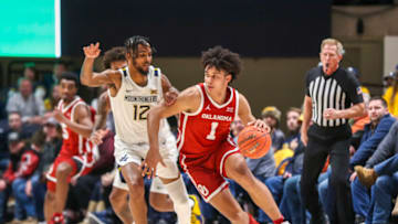 Jan 26, 2022; Morgantown, West Virginia, USA; Oklahoma Sooners forward Jalen Hill (1) dribbles with pressure from West Virginia Mountaineers guard Taz Sherman (12) during the second half at WVU Coliseum. Mandatory Credit: Ben Queen-USA TODAY Sports