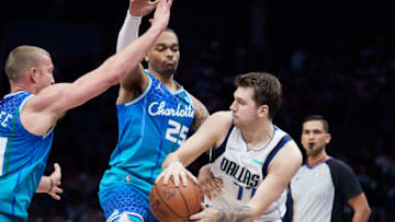 Mar 19, 2022; Charlotte, North Carolina, USA; Dallas Mavericks guard Luka Doncic (77) controls the ball against Charlotte Hornets forward P.J. Washington (25) and center Mason Plumlee (24) at Spectrum Center. Mandatory Credit: Brian Westerholt-USA TODAY Sports