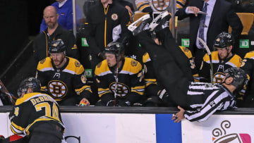 BOSTON, MA - DECEMBER 27: Boston Bruins Jake DeBrusk and Ottawa Senators Nate Thompson battle for the puck and push a linesman (84) over the Bruins bench during a game at the TD Garden in Boston, Dec. 27, 2017. (Photo by Jim Davis/The Boston Globe via Getty Images)