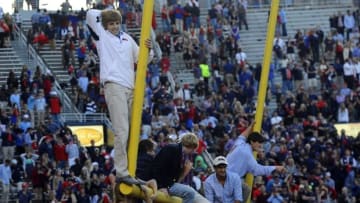 Oct 4, 2014; Oxford, MS, USA; Mississippi Rebels fans hang from the goal posts after a win against the Alabama Crimson Tide at Vaught-Hemingway Stadium. The Rebels won 23-17. Mandatory Credit: Christopher Hanewinckel-USA TODAY Sports