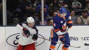 UNIONDALE, NEW YORK - DECEMBER 01: Scott Harrington #4 of the Columbus Blue Jackets and Ryan Pulock #6 of the New York Islanders battle for the puck during the first period at the Nassau Veterans Memorial Coliseum on December 01, 2018 in Uniondale, New York. The Islanders were playing in their first regular season game since April of 2015 when the team moved their home games to the Barclays Center in Brooklyn. (Photo by Bruce Bennett/Getty Images)