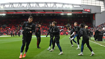 Manchester United's English defender Harry Maguire (L) warms up with the other reserves ahead of the English Premier League football match between Liverpool and Manchester United at Anfield in Liverpool, north west England on March 5, 2023. (Photo by Paul ELLIS / AFP) / RESTRICTED TO EDITORIAL USE. No use with unauthorized audio, video, data, fixture lists, club/league logos or 'live' services. Online in-match use limited to 120 images. An additional 40 images may be used in extra time. No video emulation. Social media in-match use limited to 120 images. An additional 40 images may be used in extra time. No use in betting publications, games or single club/league/player publications. / (Photo by PAUL ELLIS/AFP via Getty Images)