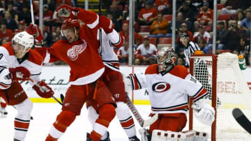 Oct 27, 2015; Detroit, MI, USA; Detroit Red Wings left wing Justin Abdelkader (8), Carolina Hurricanes defenseman Ron Hainsey (65) and center Victor Rask (49) fight for position in front of goalie Cam Ward (30) in the third period at Joe Louis Arena. Carolina won 3-1. Mandatory Credit: Rick Osentoski-USA TODAY Sports