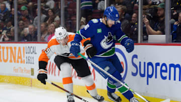 VANCOUVER, CANADA - FEBRUARY 18: Riley Stillman #61 of the Vancouver Canucks and Noah Cates #49 of the Philadelphia Flyers battle for the puck during the third period of their NHL game at Rogers Arena on February 18, 2023 in Vancouver, British Columbia, Canada. (Photo by Derek Cain/Getty Images)