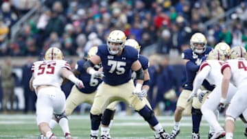 SOUTH BEND, IN - NOVEMBER 23: Josh Lugg #75 of the Notre Dame Fighting Irish blocks during a game against the Boston College Eagles at Notre Dame Stadium on November 23, 2019 in South Bend, Indiana. Notre Dame defeated Boston College 40-7. (Photo by Joe Robbins/Getty Images)