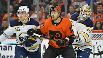 Feb 26, 2019; Philadelphia, PA, USA; Philadelphia Flyers left wing Michael Raffl (12) battles with Buffalo Sabres defenseman Rasmus Ristolainen (55) and goaltender Carter Hutton (40) during the second period at Wells Fargo Center. Mandatory Credit: Eric Hartline-USA TODAY Sports