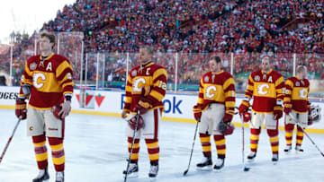 CALGARY, CANADA - FEBRUARY 20: Jay Bouwmeester #4 and teammates of the Calgary Flames stands during the pre-game ceremonies before the game against the Montreal Canadiens on February 20, 2011 during the 2011 Heritage Classic at McMahon Stadium in Calgary, Alberta, Canada. The Flames won 4-0. (Photo by Gerry Thomas/NHLI via Getty Images)