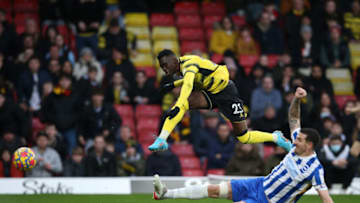 WATFORD, ENGLAND - FEBRUARY 12: Ismaila Sarr of Watford FC shoots past Lewis Dunk of Brighton & Hove Albion during the Premier League match between Watford and Brighton & Hove Albion at Vicarage Road on February 12, 2022 in Watford, England. (Photo by Steve Bardens/Getty Images)