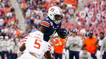 Auburn footballDec 28, 2021; Birmingham, Alabama, USA; Houston Cougars safety Hasaan Hypolite (5) reaches out for Auburn Tigers running back Tank Bigsby (4) during the second half of the 2021 Birmingham Bowl at Protective Stadium. Mandatory Credit: Marvin Gentry-USA TODAY Sports