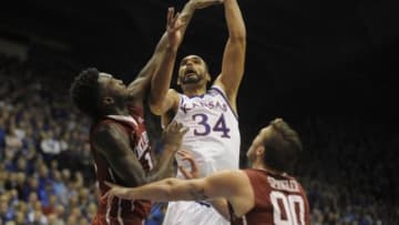 Jan 4, 2016; Lawrence, KS, USA; Kansas Jayhawks forward Perry Ellis (34) shoots against Oklahoma Sooners guard Jordan Woodard (10) and forward Ryan Spangler (00) in the second at Allen Fieldhouse. Kansas won the game 109-106 in triple overtime. Mandatory Credit: John Rieger-USA TODAY Sports