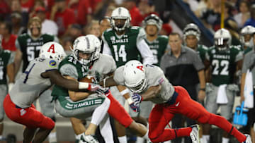 TUCSON, AZ - SEPTEMBER 17: Wide receiver Dylan Collie #23 of the Hawaii Warriors is tackled by linebackers Paul Magloire Jr. #14 and DeAndre' Miller #32 of the Arizona Wildcats after a reception during the first quarter of the college football game at Arizona Stadium on September 17, 2016 in Tucson, Arizona. (Photo by Christian Petersen/Getty Images)