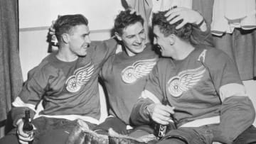 (Original Caption) Three of the Detroit Redwings make merry in the dressing room after they scored a victory over Montreal in the first game of the Stanley Cup finals. (Left to right) Tony Leswick, who scored 2 of the Wings' 3 goals; goalie Terry Sawchuck and Ted Lindsay, who scored the 3rd goal. Score was 3-1.