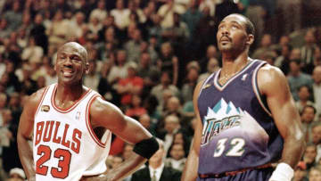 Michael Jordan (L) of the Chicago Bulls smiles while standing next to Karl Malone of the Utah Jazz 07 June in the first half of game three of the NBA Finals at the United Center in Chicago, IL. The seven game series is tied at 1-1. AFP PHOTO Jeff HAYNES (Photo by JEFF HAYNES / AFP) (Photo by JEFF HAYNES/AFP via Getty Images)