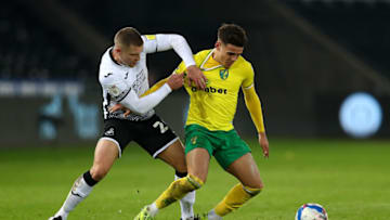 SWANSEA, WALES - FEBRUARY 05: Max Aarons of Norwich City is tackled by Jake Bidwell of Swansea City during the Sky Bet Championship match between Swansea City and Norwich City at Liberty Stadium on February 05, 2021 in Swansea, Wales. Sporting stadiums around the UK remain under strict restrictions due to the Coronavirus Pandemic as Government social distancing laws prohibit fans inside venues resulting in games being played behind closed doors. (Photo by Dan Istitene/Getty Images)