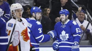 Apr 1, 2014; Toronto, Ontario, CAN; Toronto Maple Leafs defenseman Carl Gunnarsson (36) congratulates forward Dave Bolland (63) on a goal against the Calgary Flames during the third period at the Air Canada Centre. Toronto defeated Calgary 3-2. Mandatory Credit: John E. Sokolowski-USA TODAY Sports