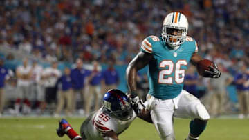 Dec 14, 2015; Miami Gardens, FL, USA; New York Giants linebacker J.T. thomas (55) falls behind as Miami Dolphins running back Lamar Miller (26) scores on a first quarter run at Sun Life Stadium. Mandatory Credit: Andrew Innerarity-USA TODAY Sports