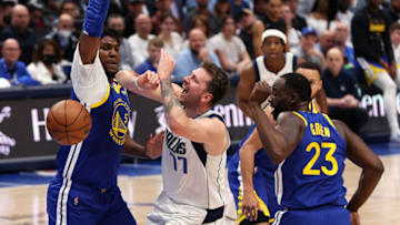 DALLAS, TEXAS - MAY 24: Luka Doncic #77 of the Dallas Mavericks loses control of the ball driving to the basket against Kevon Looney #5 and Draymond Green #23 of the Golden State Warriors during the first quarter in Game Four of the 2022 NBA Playoffs Western Conference Finals at American Airlines Center on May 24, 2022 in Dallas, Texas. NOTE TO USER: User expressly acknowledges and agrees that, by downloading and or using this photograph, User is consenting to the terms and conditions of the Getty Images License Agreement. (Photo by Tom Pennington/Getty Images)
