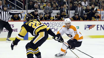 Feb 15, 2022; Pittsburgh, Pennsylvania, USA; Philadelphia Flyers center Scott Laughton (21) moves the puck against Pittsburgh Penguins defenseman Marcus Pettersson (28) during the third period at PPG Paints Arena. The Penguins won 5-4 in overtime. Mandatory Credit: Charles LeClaire-USA TODAY Sports