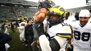 EAST LANSING, MI - OCTOBER 20: Devin Bush #10 of the Michigan Wolverines carries the Paul Bunyan trophy off the field after beating the Michigan State Spartans 21-7 at Spartan Stadium on October 20, 2018 in East Lansing, Michigan. (Photo by Gregory Shamus/Getty Images)