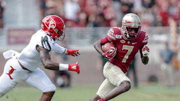 TALLAHASSEE, FL - SEPTEMBER 21: Wide Receiver D.J. Matthews #7 of the Florida State Seminoles avoids a tackle by Linebacker C.J. Avery #9 of the Louisville Cardinals during the game at Doak Campbell Stadium on Bobby Bowden Field on September 21, 2019 in Tallahassee, Florida. The Seminoles defeated the Cardinals 35 to 24. (Photo by Don Juan Moore/Getty Images)